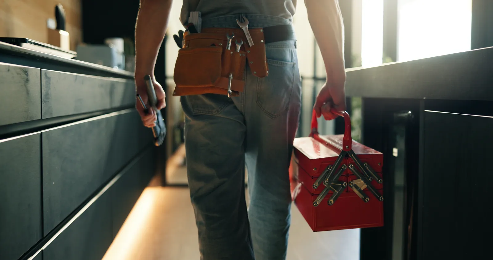 BC Plumbing plumber with toolbelt and toolbox on the job